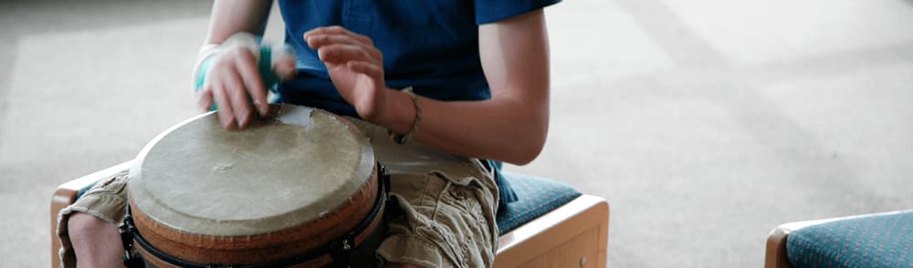 playing a wooden drum